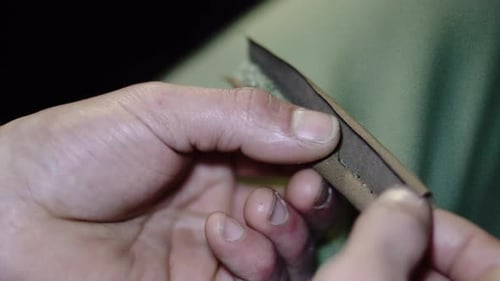 Hands Carefully Working with Brown Material Close Up