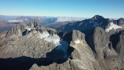 Scenic aerial view flying over high mountain peaks in New Zealand.