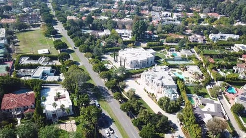 Car on Sunset boulevard in Beverly Hills. Luxury villa buildings and mansion during sunny day in Cal