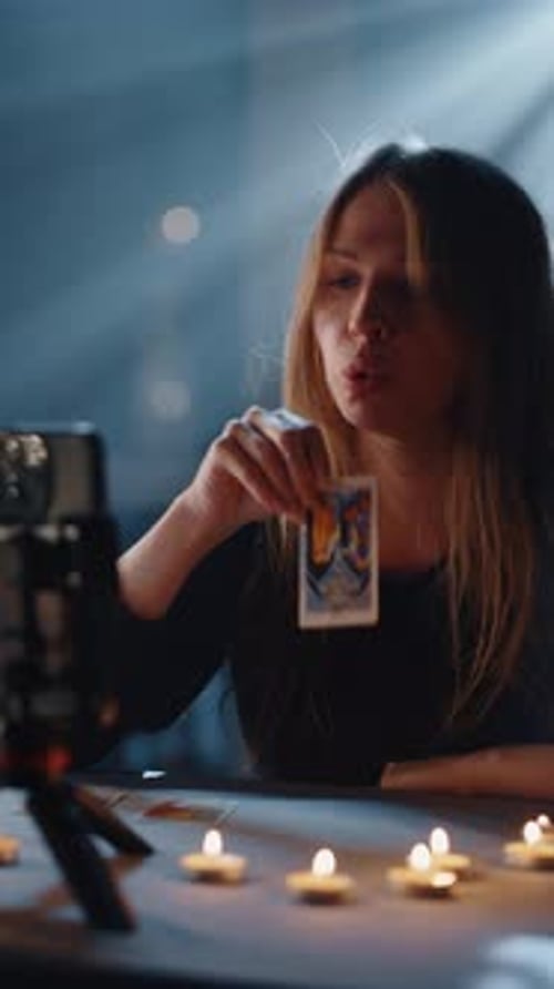 Woman doing Tarot reading with candles at night