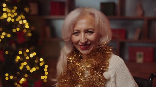 Smiling Senior Woman with Christmas Tree Background