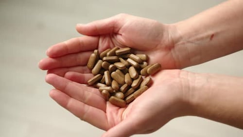 Mädchen zeigt dunkle medizinische Pillen für natürliche Gesundheit und Schönheit