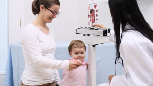 Baby Examined by Doctor and Mother in Clinic