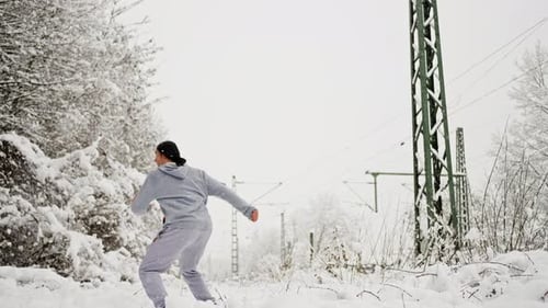 Man Does Leg Split Jump Kick in Snowy Landscape