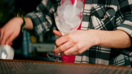 Bartender Pouring Ice in a Glass at a Bar