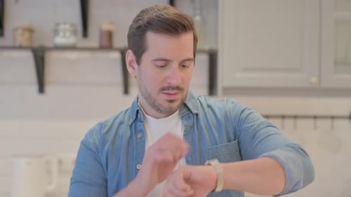 Man Checking Watch Indoors Waiting
