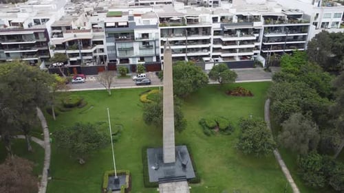 4k drone video of a park with a obelisc. Drone flies in orbit around the obelisc monument from left