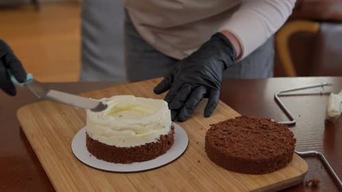 Person Frosting Layer Cake With Spatula in Kitchen