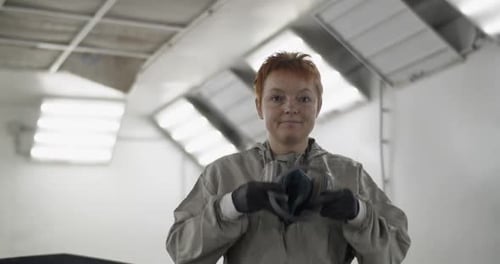 Woman Puts on Respirator in Industrial Workspace