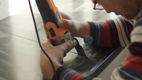Worker Cutting Countertop Edge with Electric Grinder