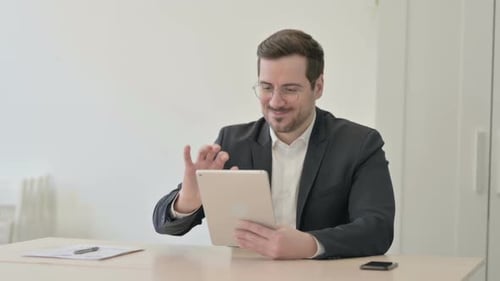 Young Adult Celebrates Success on Tablet in Office