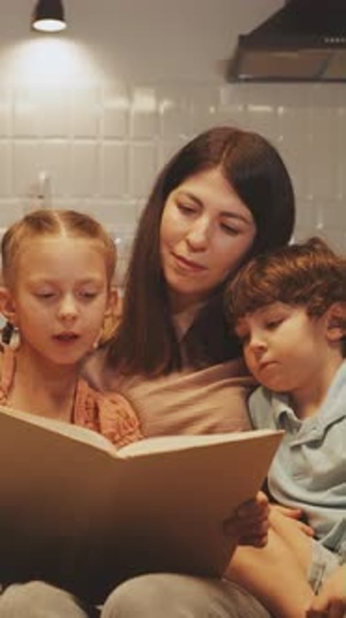 Mother Reading Book with Children at Home