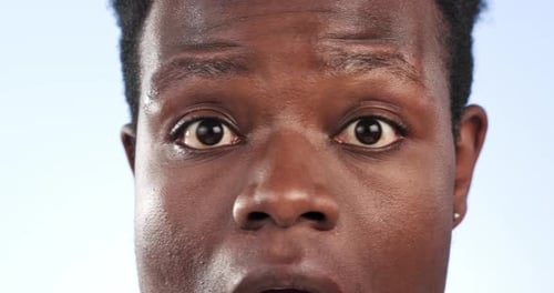 Face, wow and surprise of happy man closeup in studio isolated on a blue background