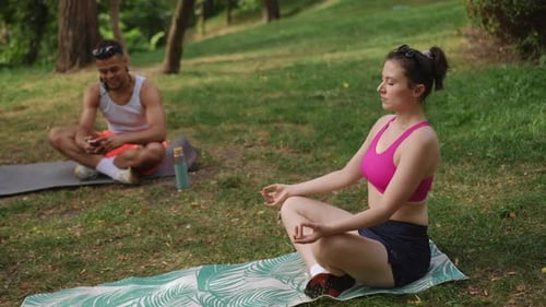 Woman Meditating Outdoors with Friend in Park