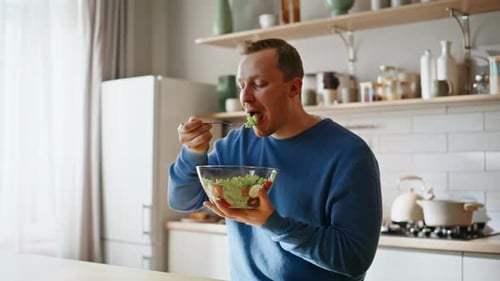 Man Enjoying Healthy Salad in Bright Kitchen