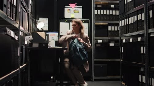 Woman Working at Desk in Small Dark Office