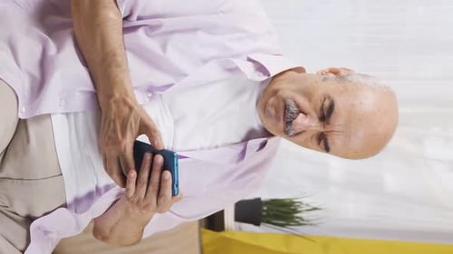 Senior Man Using Smartphone Indoors, Portrait Orientation