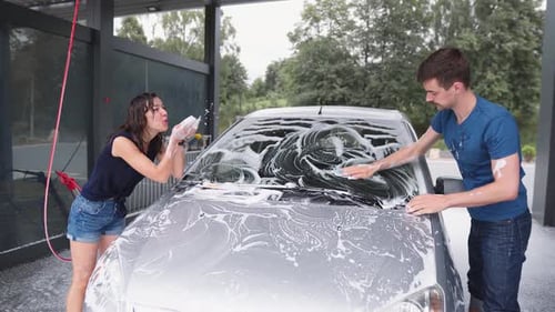 Couple Washing Car Together at Car Wash