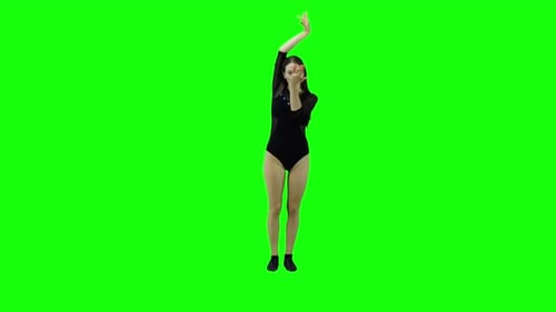 Beautiful slim girl dancing slowly on a green background