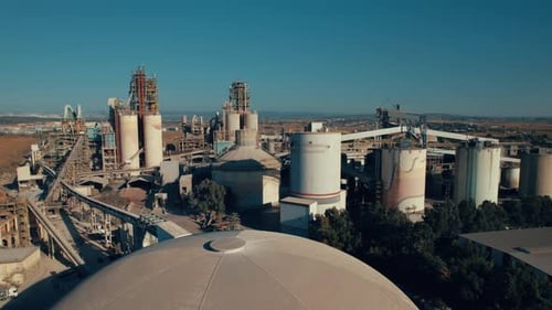 Aerial shot of a huge cement factory, innovative industrial area with lots of hangars and trucks, be