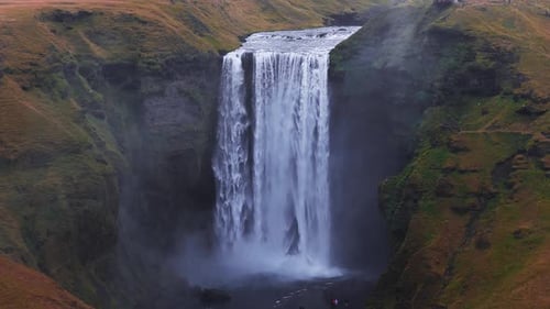 Skogafoss Waterfall Flowing Through Green Cliffs in Iceland