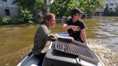 Voluntarios navegan en barco para evacuar animales y personas tras la detonación de la energía hidroeléctrica