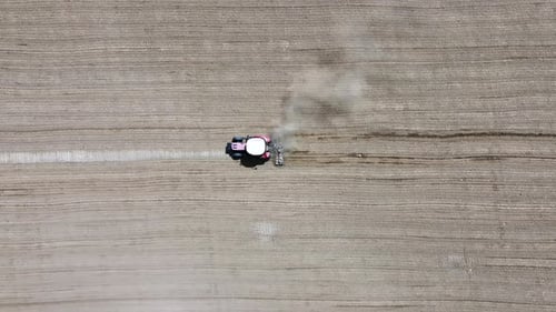 Tractor plowing the field - Red tractor plowing the field, 4k aerial shot with drone