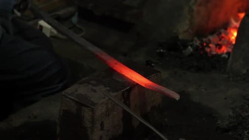 Blacksmith Shaping Hot Metal on Anvil with Hammer