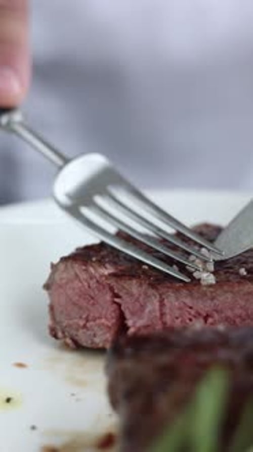 A man is eating a steak. Close-up