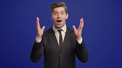 Excited Man Celebrating in Suit on Blue Background