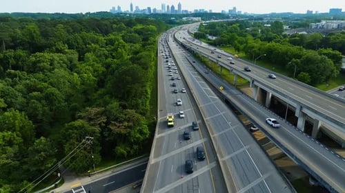 Interstate highways with traffic in rural area. Skyline silhouette with skyscraper in Atlanta, Georg