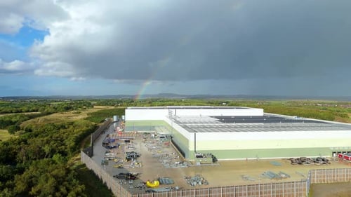 Drone flyover of freight trucks and industrial buildings at logistics centre in Coalville United