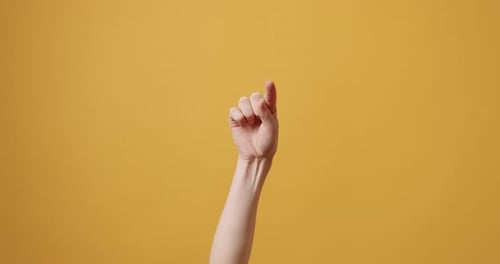 Hand Gesturing and Pointing on Yellow Background