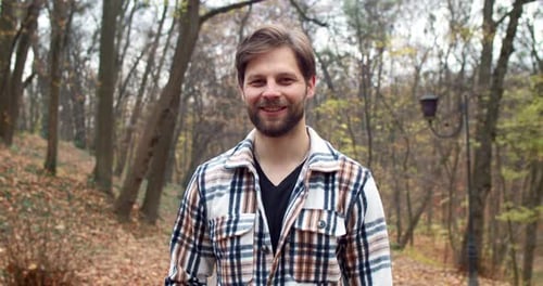 Closeup Portrait of Stylish Cute Handsome Man in Casual Clothes Standing in Autumn Park Looking at