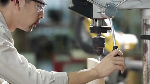 Skilled carpenters handmade craftsman woodworker in workshop with a block of wooden, drilling hole a