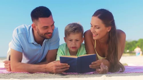Loving family reading a book together on beach