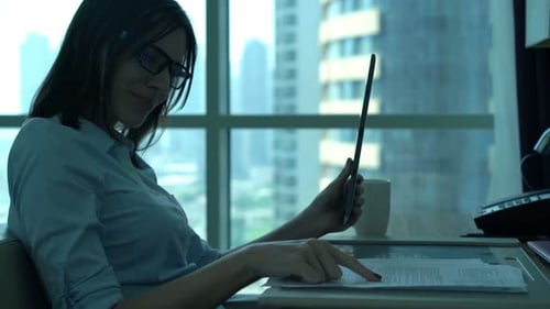 Junge Geschäftsfrau analysiert Finanzdaten auf einem Tablet-Computer im modernen Büro
