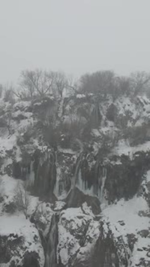 Waterfall Flowing From Snowy Hill