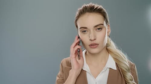 Businesswoman Talking on Phone in Studio, Close Up