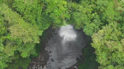 Aerial View of White Cascade Crashing Into Jungle Pool in Bali Indonesia