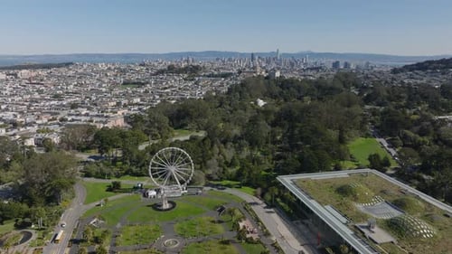 Aufsteigende Luftaufnahmen von Attraktionen mit Blick auf den Stadtpark, wobei Gebäude in der Stadt und Hochhäuser zu sehen sind