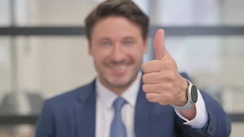 Close Up of Thumbs Up by Businessman