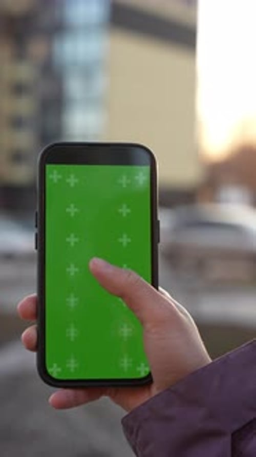Smartphone Displaying Green Screen Female Hand Scrolling Touchscreen During Slow Motion Outdoor