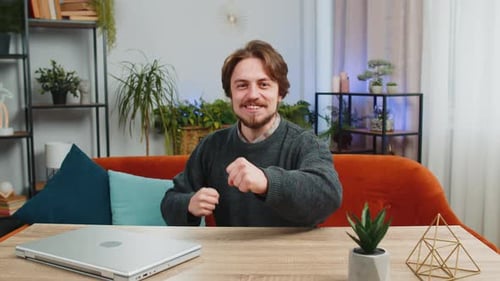 Excited Man Celebrating Success at Desk