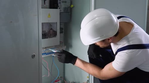 Electrician Working on Electrical Equipment at Workplace