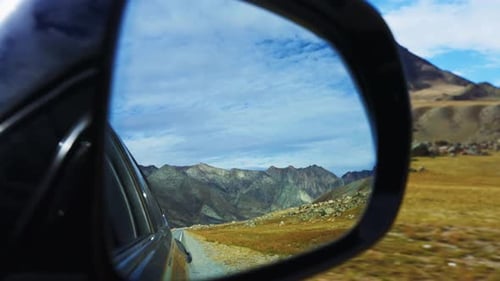 A Breathtaking Scenic Mountain View Reflected Beautifully in the Car Mirror While Enjoying a