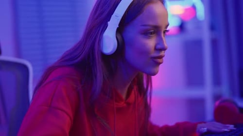 Woman Plays Video Game in Neon Lit Room