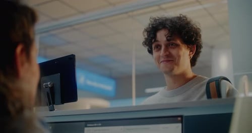 Female Airline Agent Checking Documents Giving Passport and Boarding Pass to Passenger