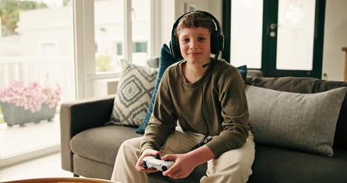 Boy with Headset Smiles While Gaming on Couch
