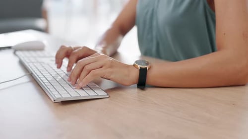 Hands Typing on Computer Keyboard at Desk